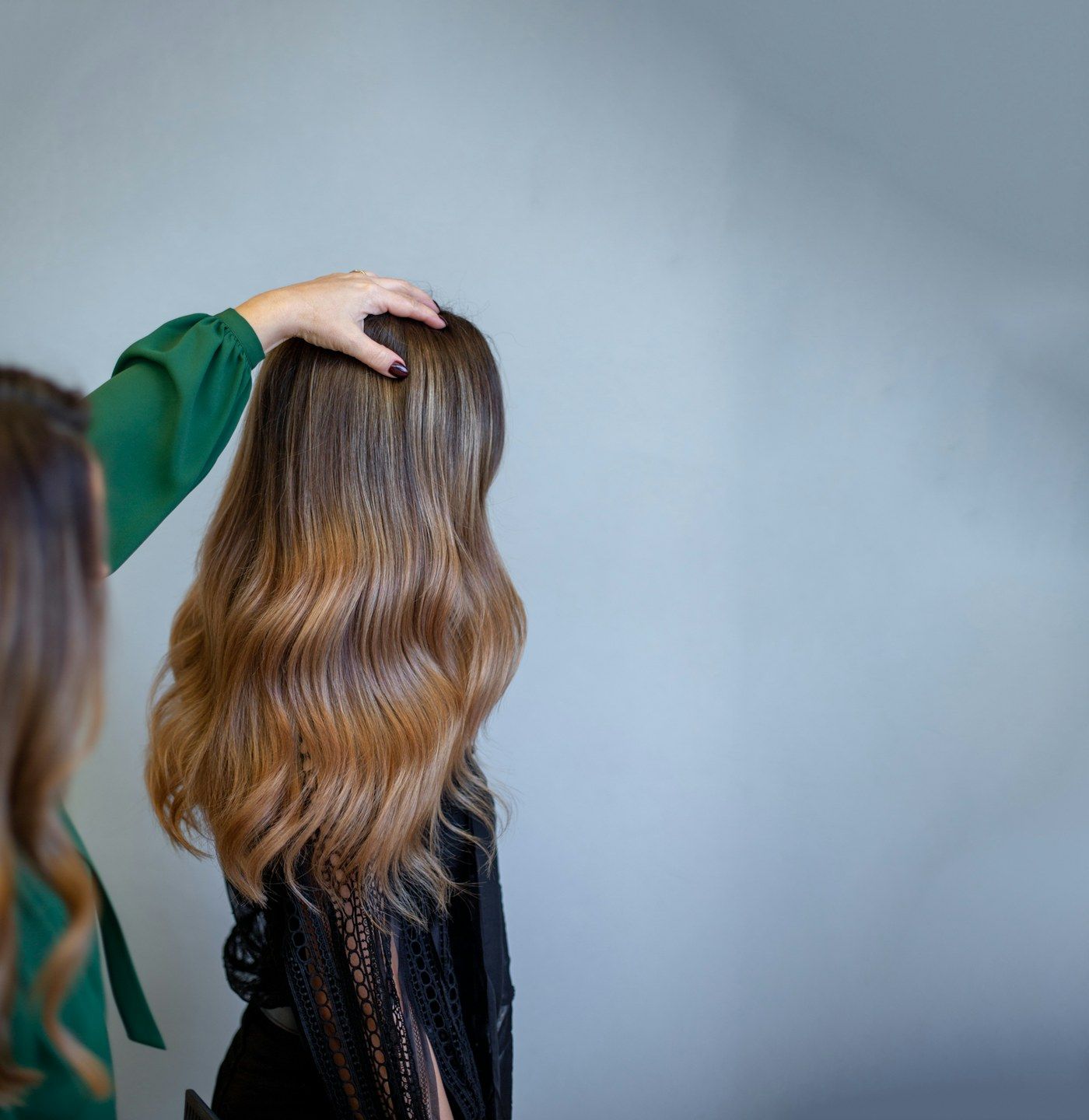 Cabelo castanho longo com as pontas iluminadas em tom caramelo, visto de costas